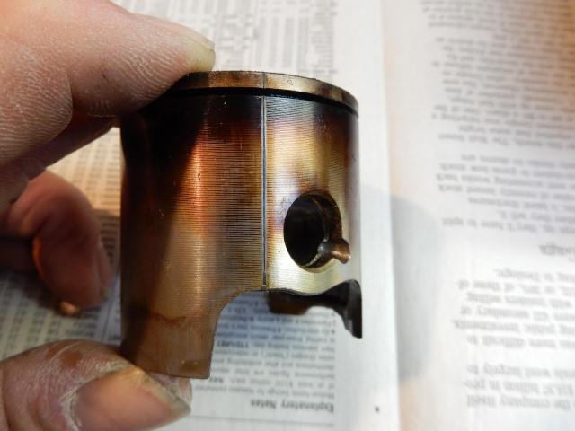 overheated piston showing burnt oil on the skirts