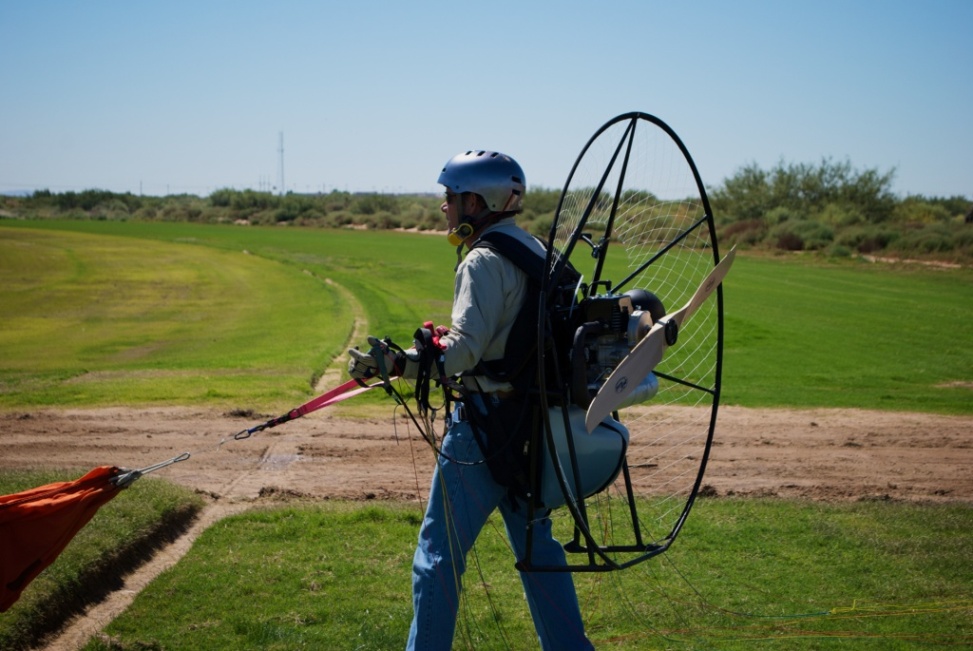 powered paraglider pilot prepares to be towed up during training